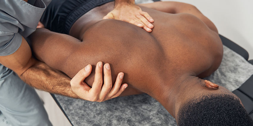 Austin chiropractor at True Chiropractic adjusting patient's shoulder to relieve pain